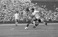 Pelé, wearing the Santos shirt , dribbles a defender on the edge of the penalty area.